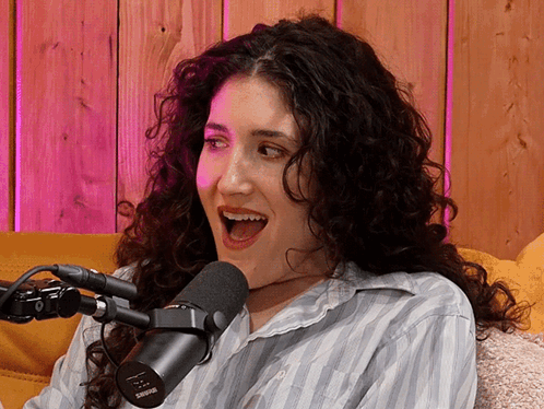 A Woman Sitting In Front Of A Shure Microphone With Her Mouth Wide Open GIF