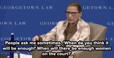 A Woman Sitting In Front Of A Sign That Says ' Georgetown Law ' On It GIF