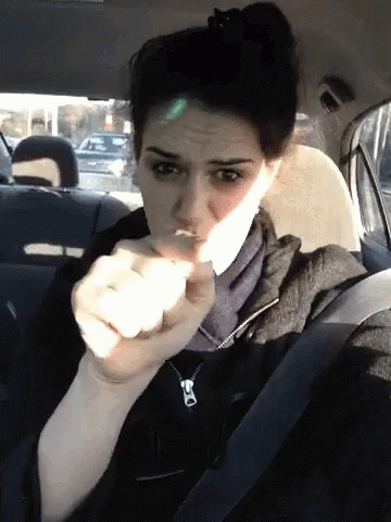 A Woman Sitting In The Back Seat Of A Car Making A Face GIF