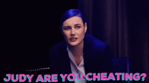 A Woman Sitting Next To Another Woman With Judy Are You Cheating Written On The Bottom GIF