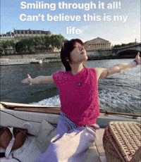 A Woman Sitting On A Boat With Her Arms Outstretched With The Caption Smiling Through It All Can 'T Believe This Is My L GIF