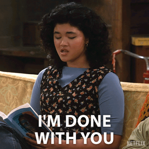 A Woman Sitting On A Couch Reading A Book With The Words I 'M Done With You Below Her GIF
