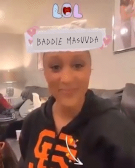 A Woman Sitting On A Couch With A Lol Sign On Her Head . GIF
