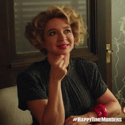 A Woman Sitting On A Couch With #Happytimemurders Written On The Bottom Right GIF