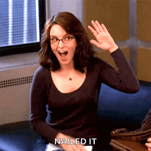 A Woman Sitting On A Couch With Her Hand Up And The Words Nailed It Written Below Her GIF
