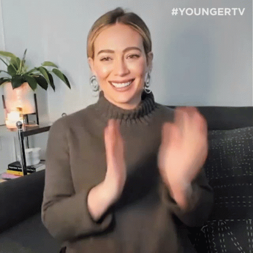 a woman sitting on a couch with her hands in the air and the hashtag youngertv