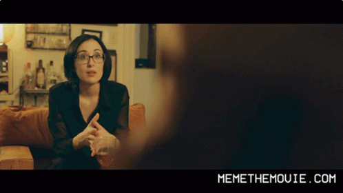 A Woman Sitting On A Couch With Memethemovie.com Written On The Bottom Of The Screen GIF