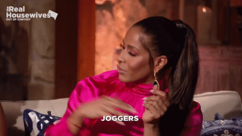 A Woman Sitting On A Couch With The Word Joggers Written On Her Face GIF