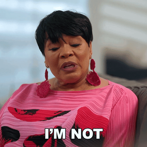 A Woman Sitting On A Couch With The Words I 'M Not On Her Shirt GIF