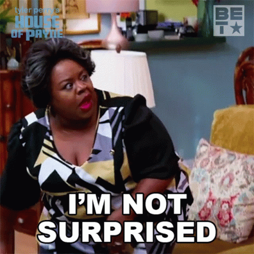 A Woman Sitting On A Couch With The Words I 'M Not Surprised On Her Face GIF