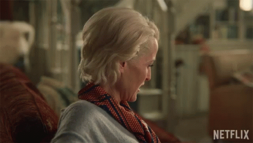 A Woman Sitting On A Couch With The Words I 'M Sorry Written On The Bottom GIF