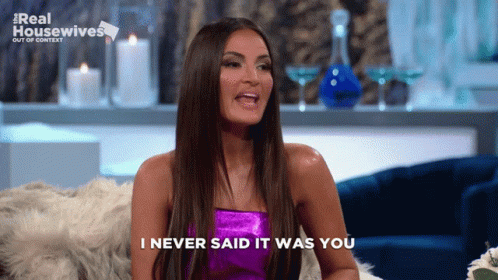A Woman Sitting On A Couch With The Words " I Never Said It Was You " Above Her GIF