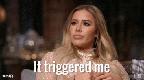 A Woman Sitting On A Couch With The Words It Triggered Me Written On Her Face GIF