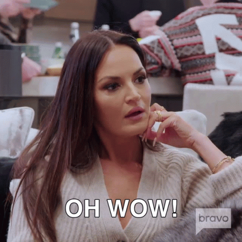 A Woman Sitting On A Couch With The Words Oh Wow Written On Her Face GIF