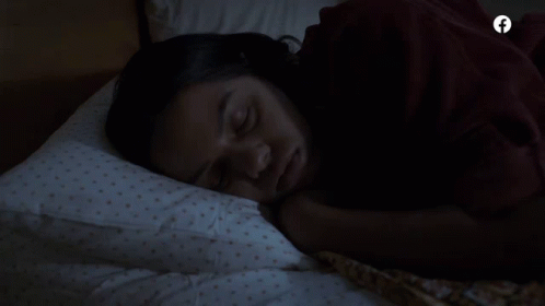 A Woman Sleeping In A Bed With A Facebook Logo On The Bottom GIF