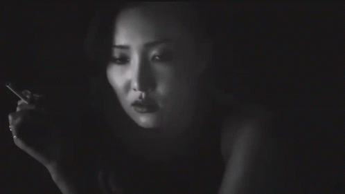 A Woman Smoking A Cigarette With A Tattoo On Her Arm That Says I Love You GIF