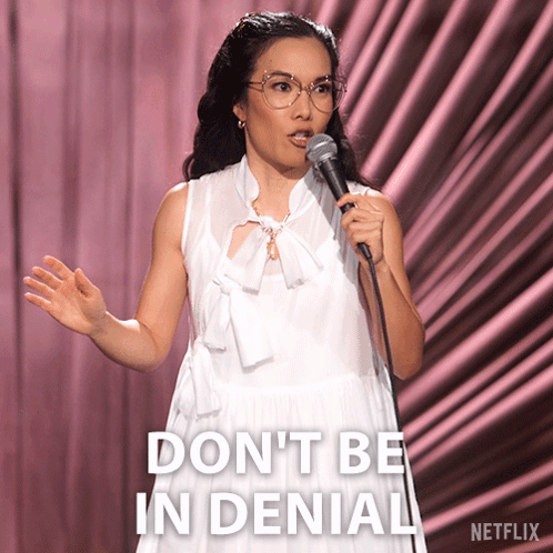 A Woman Speaking Into A Microphone With The Words " Do N't Be In Denial " Written On The Bottom GIF