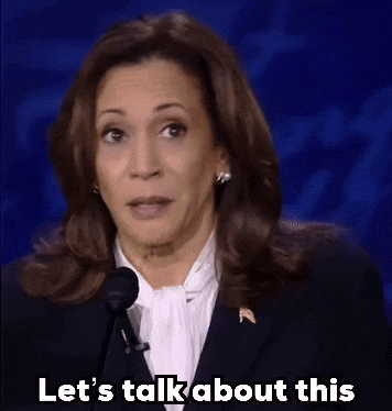 A Woman Speaking Into A Microphone With The Words Let 'S Talk About This Written Below Her GIF