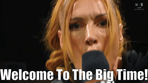 A Woman Speaking Into A Microphone With The Words Welcome To The Big Time Written Below Her GIF