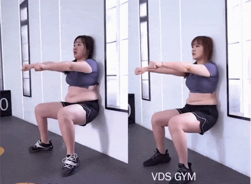 A Woman Squatting Against A Wall With The Words Vds Gym On The Bottom Right GIF