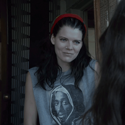 A Woman Standing In A Doorway With A Headband On GIF