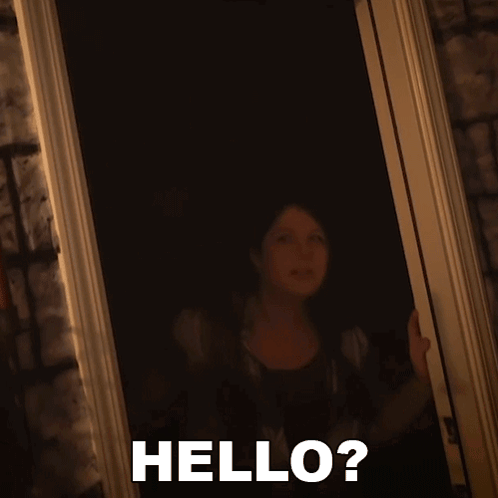 A Woman Standing In A Doorway With The Words Hello Written On The Bottom GIF