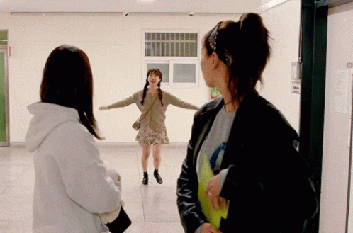 Woman Standing In Hallway With Fire Exit Sign GIF