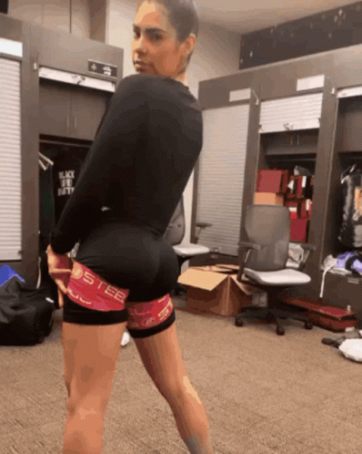 A Woman Standing In A Locker Room Wearing A Pair Of Shorts That Say Steel GIF
