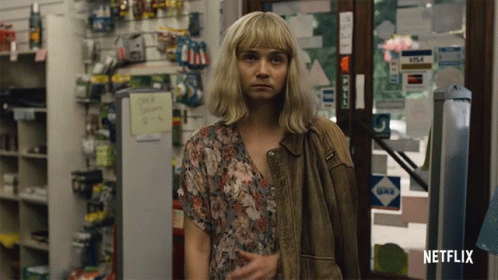 A Woman Standing In A Store With A Netflix Logo On The Bottom Right GIF