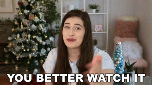 A Woman Standing In Front Of A Christmas Tree Says You Better Watch It GIF