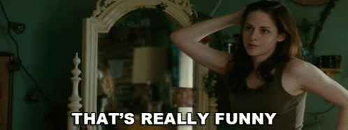 A Woman Standing In Front Of A Mirror With The Words That 'S Really Funny Written Below Her GIF