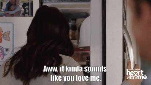 A Woman Standing In Front Of A Refrigerator With A Caption That Says Aww It Kinda Sounds Like You Love Me GIF