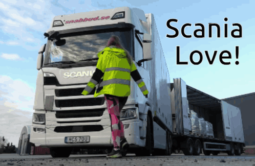 A Woman Standing In Front Of A Scania Truck That Says Scania Love GIF