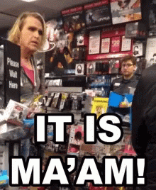 A Woman Standing In Front Of A Sign That Says It Is Ma'am GIF