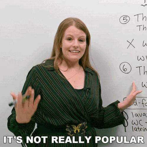 A Woman Standing In Front Of A White Board With The Words " It 'S Not Really Popular " On The Bottom GIF