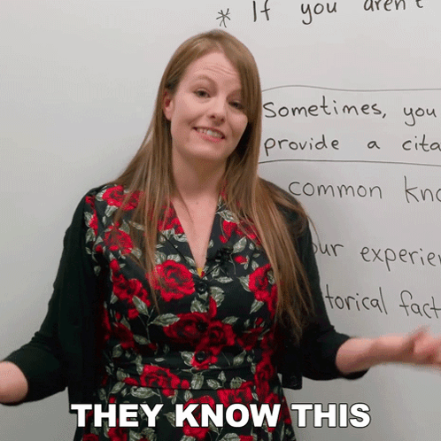 A Woman Standing In Front Of A White Board With The Words They Know This Written On It GIF