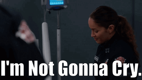 A Woman Standing In Front Of An Iv Machine With The Words I 'M Not Gonna Cry Written Above Her GIF