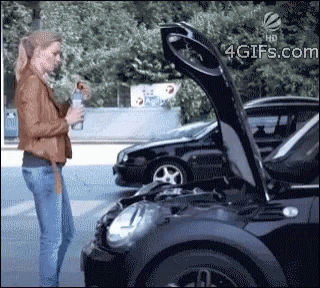 A Woman Standing Next To A Black Car With The Hood Up GIF