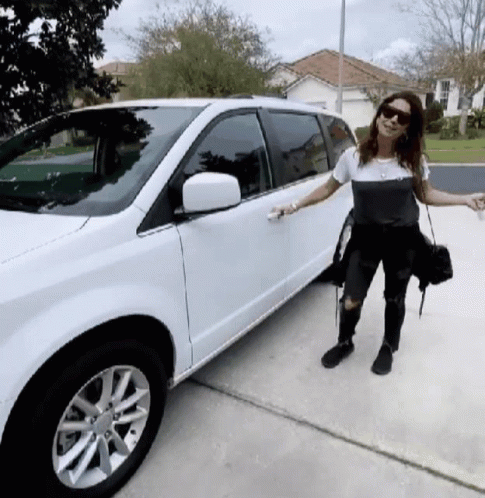 A Woman Standing Next To A White Minivan GIF