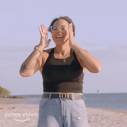 A Woman Standing On A Beach With A Prime Video Logo On The Bottom GIF
