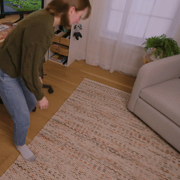 A Woman Standing On A Rug In Front Of A Computer GIF