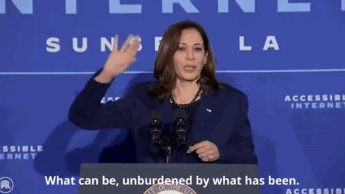 A Woman Stands At A Podium With The Words " What Can Be Unburdened By What Has Been " GIF