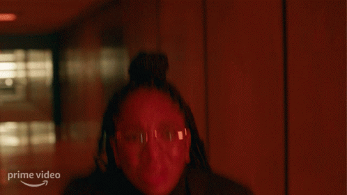 A Woman Stands In A Dark Hallway With Her Hands Up And A Prime Video Logo In The Corner GIF