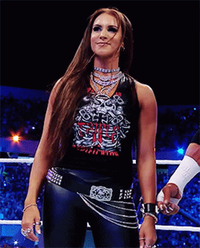 A Woman Stands In A Wrestling Ring Wearing A Shirt That Says Skeleton GIF