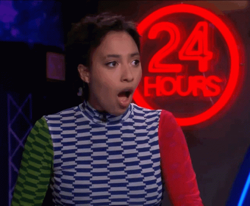 A Woman Stands In Front Of A 24 Hours Neon Sign GIF