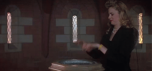 A Woman Stands In Front Of A Baptismal Font GIF