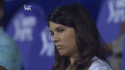 A Woman Stands In Front Of A Blue Ipl Shirt GIF