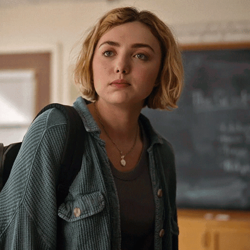 A Woman Stands In Front Of A Chalkboard That Says " The Truth " On It GIF