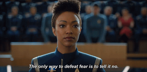 a woman stands in front of a crowd and says the only way to defeat fear is to tell it no