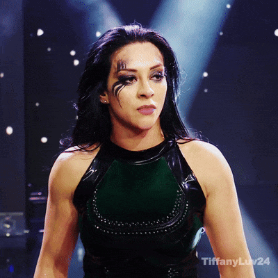 A Woman Stands In Front Of A Dark Background With Tiffanyluv24 Written On The Bottom Right GIF